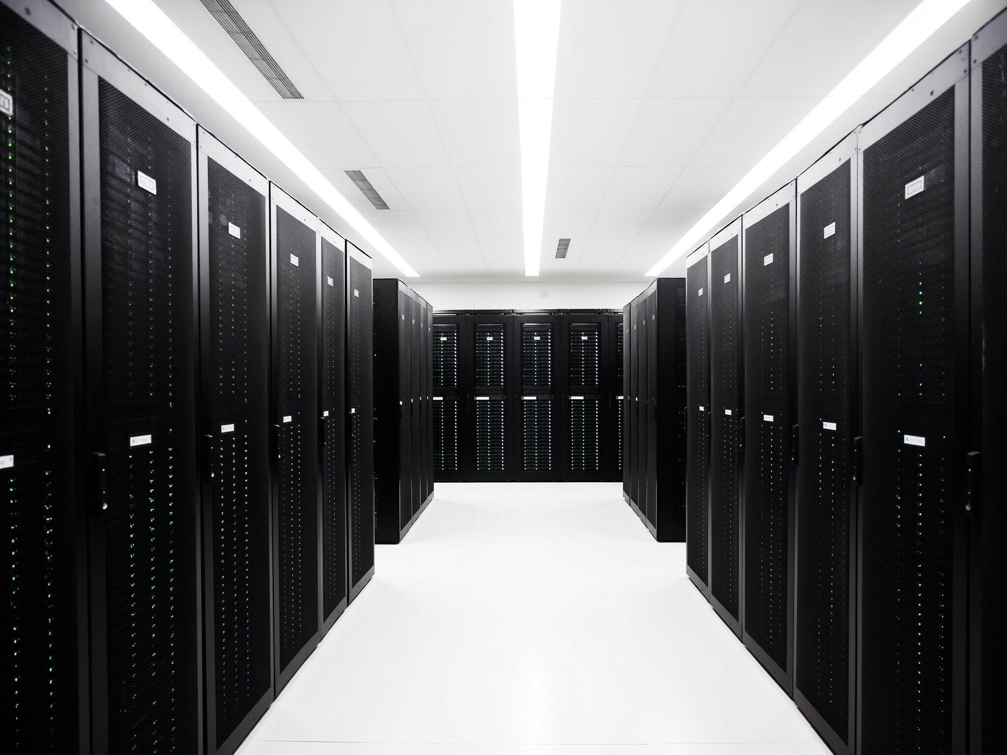 Corredor de data center claro, com fileiras de racks de servidores