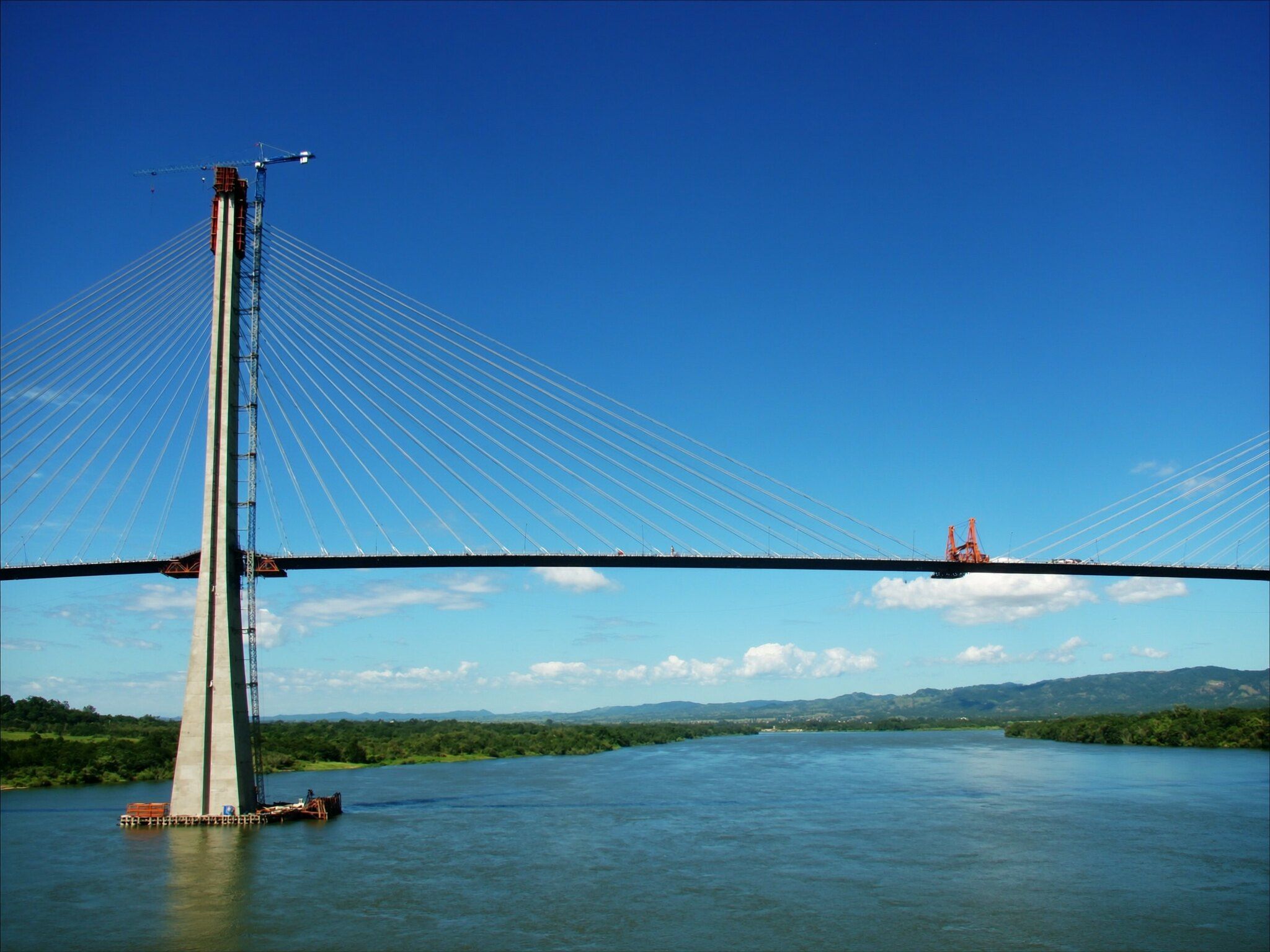Ponte estaiada sobre um rio largo em um dia de sol